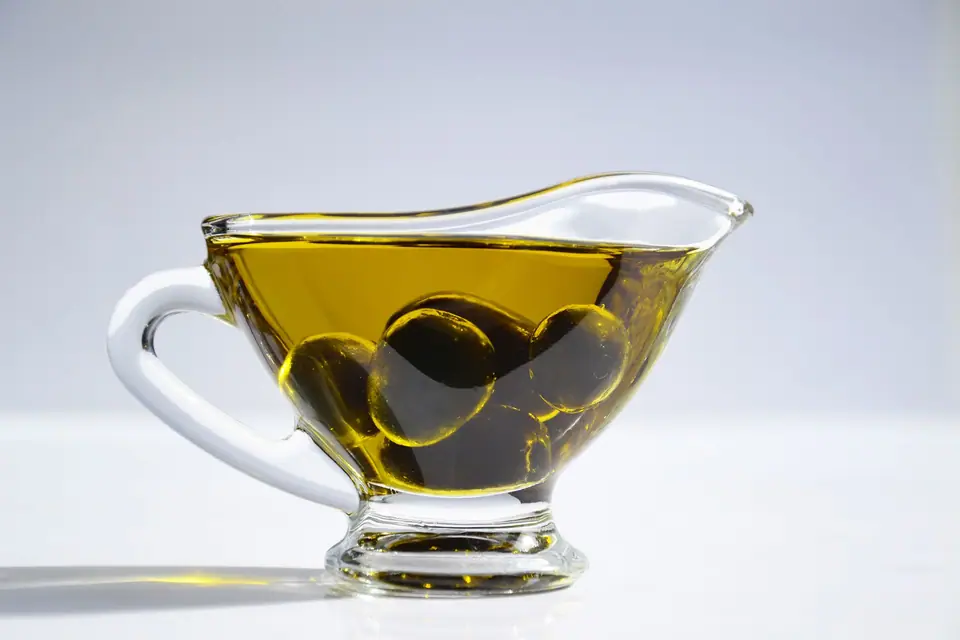 Olive oil in a glass jug with olives