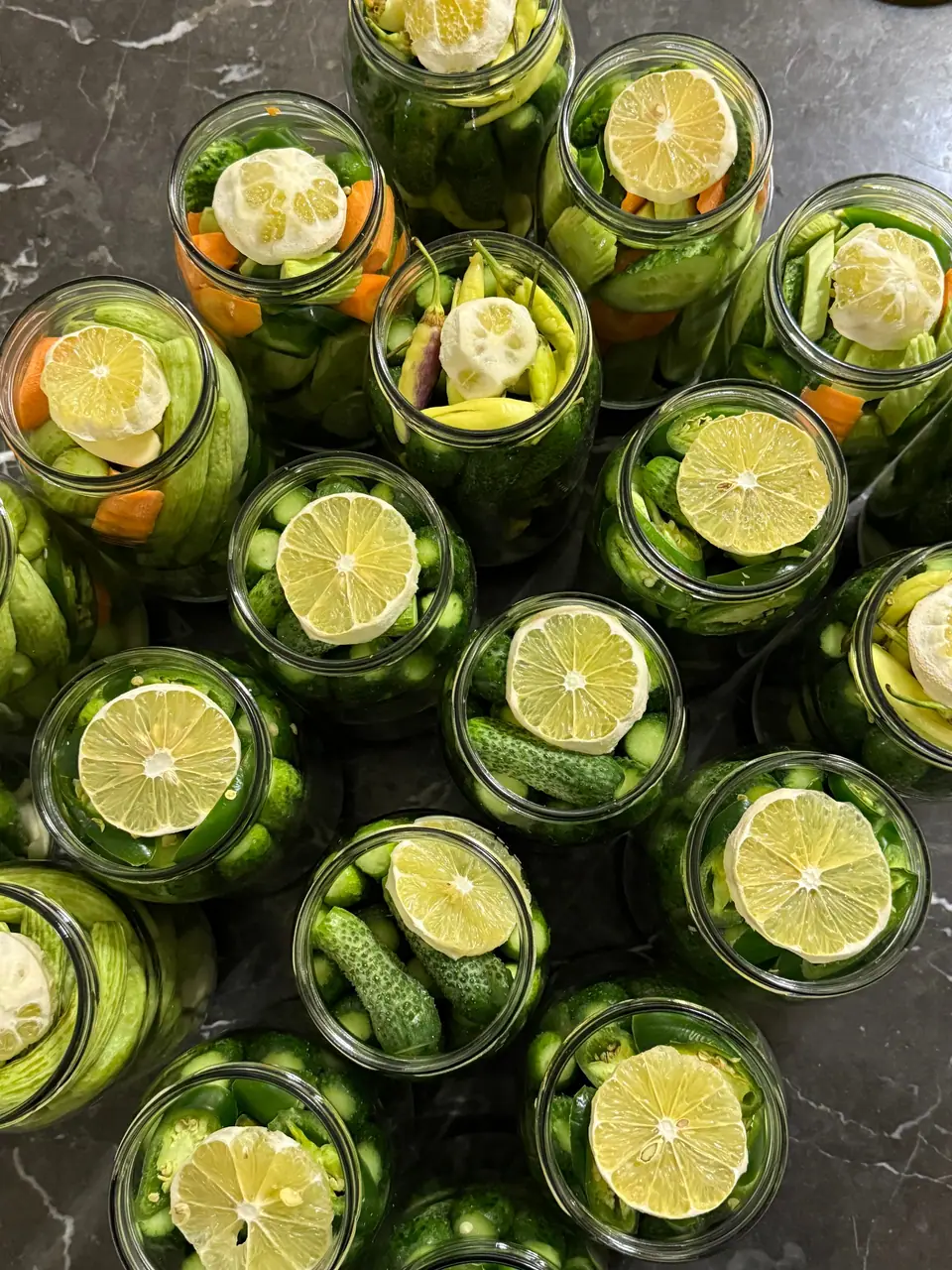 Jars of vegetables and lemons seen from above
