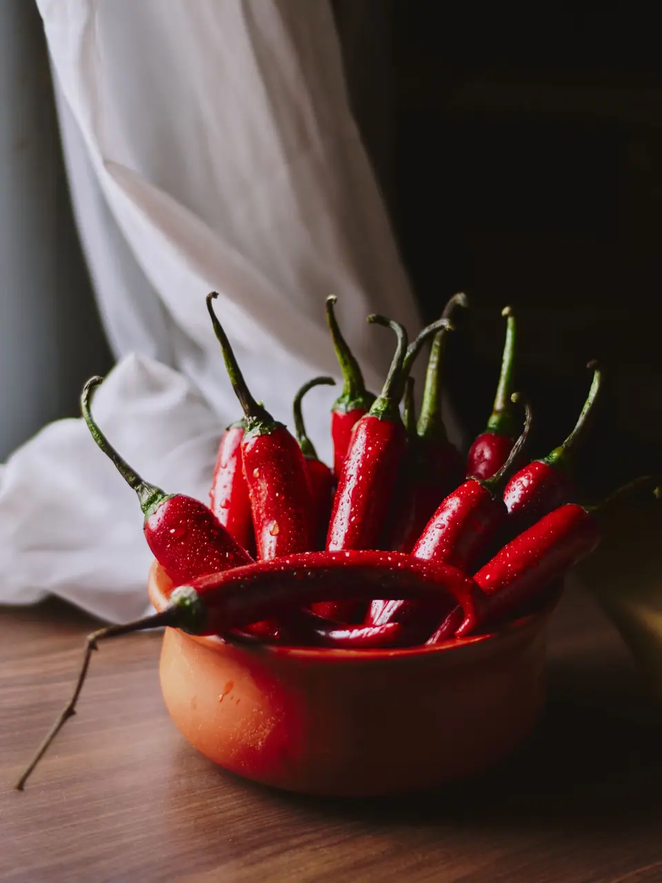 Piments rouges dans un bol en terre cuite